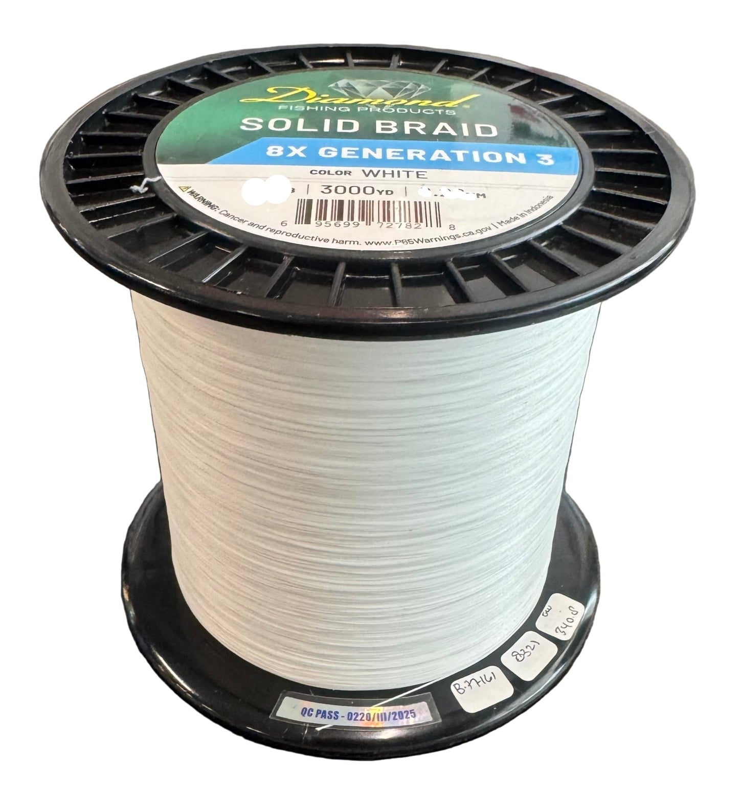 Spool of white fishing line with a label on a gray surface