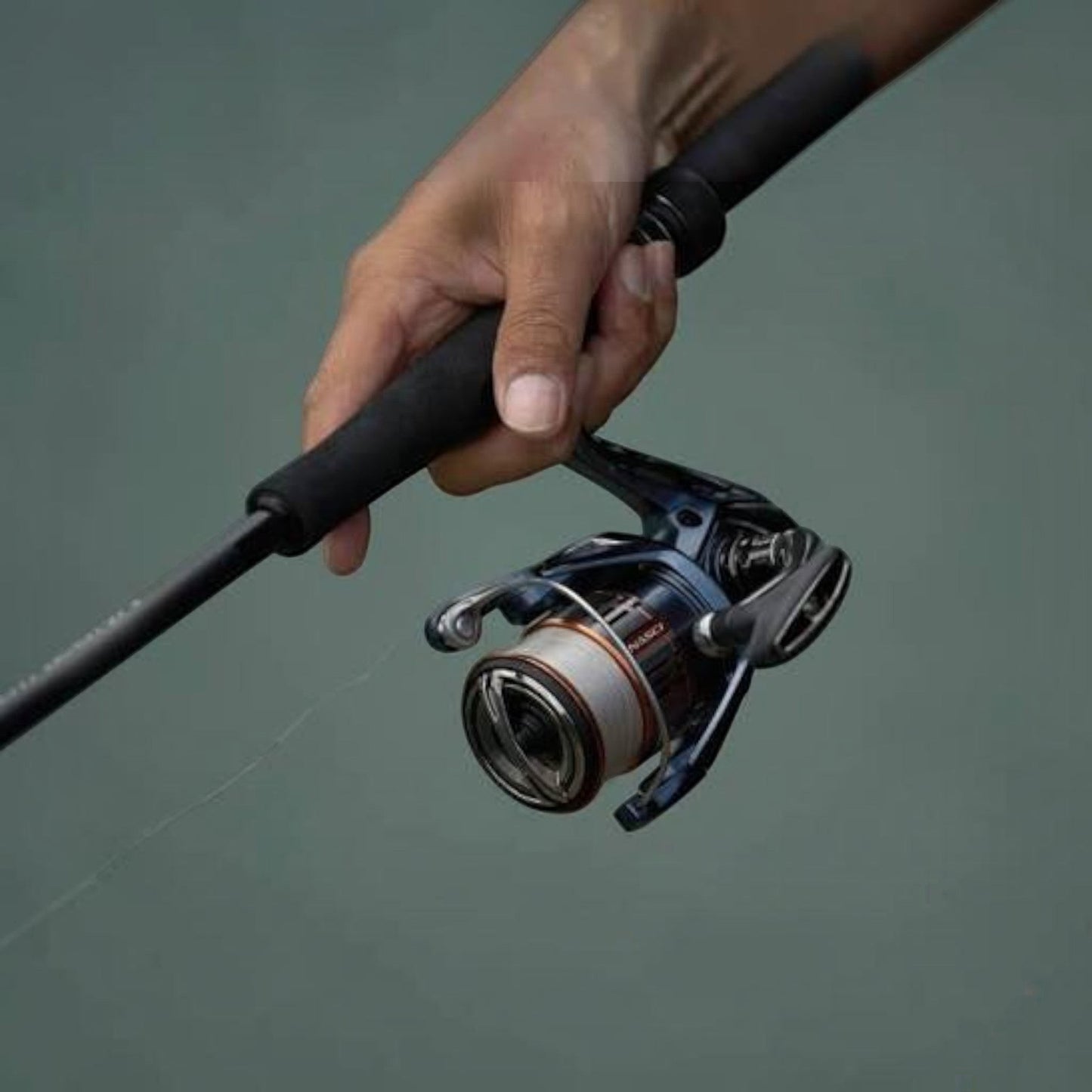 Dogfish Tackle & Marine Shimano Nasci FD spinning reel, dark blue with silver spool, held by a hand on a fishing rod.