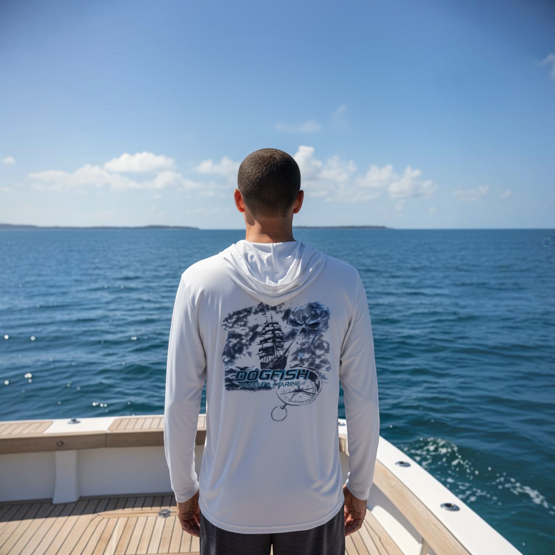 Person wearing a white long-sleeve shirt with a graphic design, standing on a boat with ocean and sky in the background.