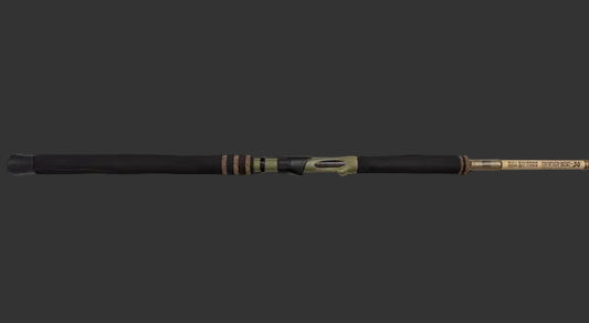 A premium fishing rod with a black handle and gold-colored metallic sections, shown diagonally against a dark, moody studio background.