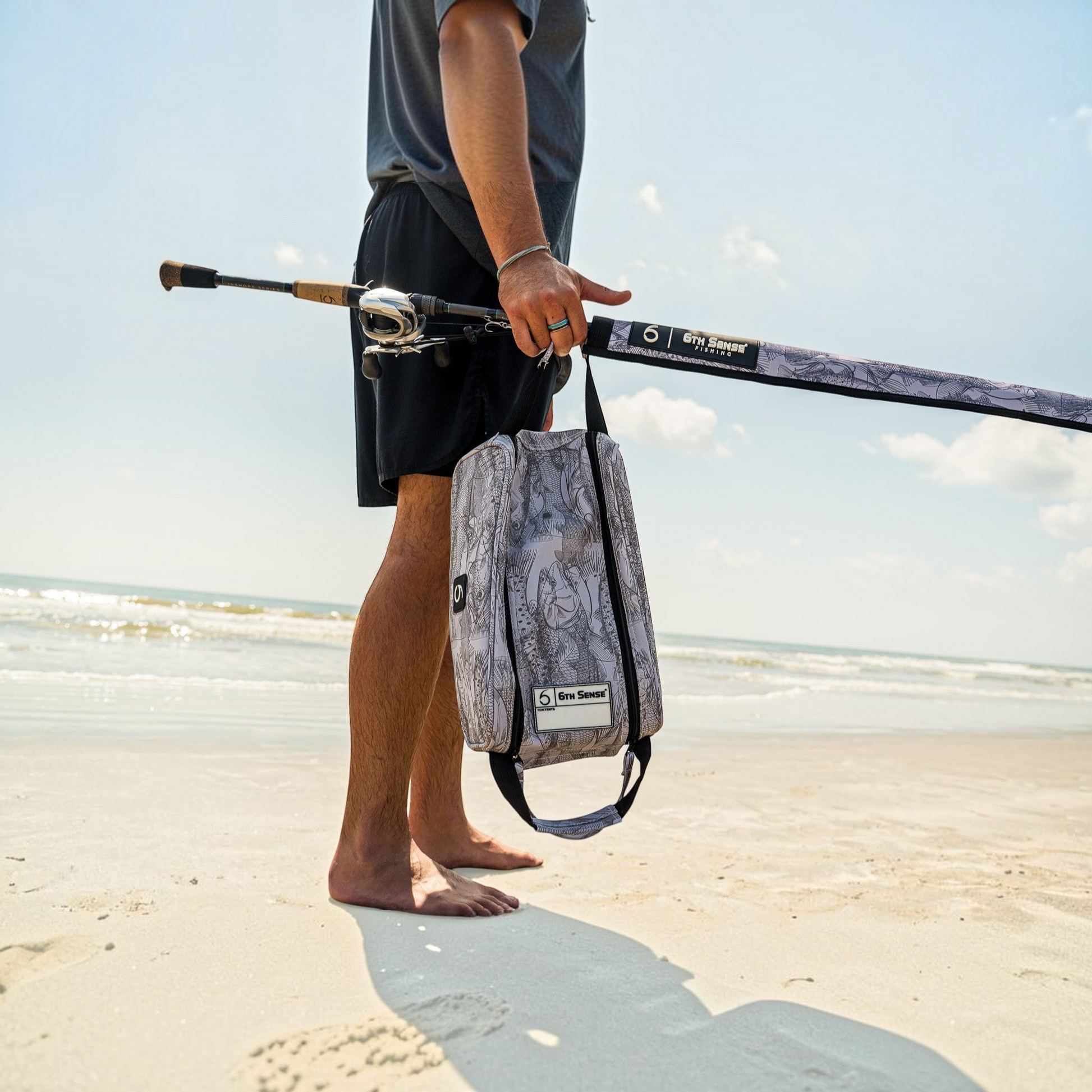 Dogfish Tackle & Marine 6th Sense extra large bait bag with grey patterned design held by a fisherman on the beach