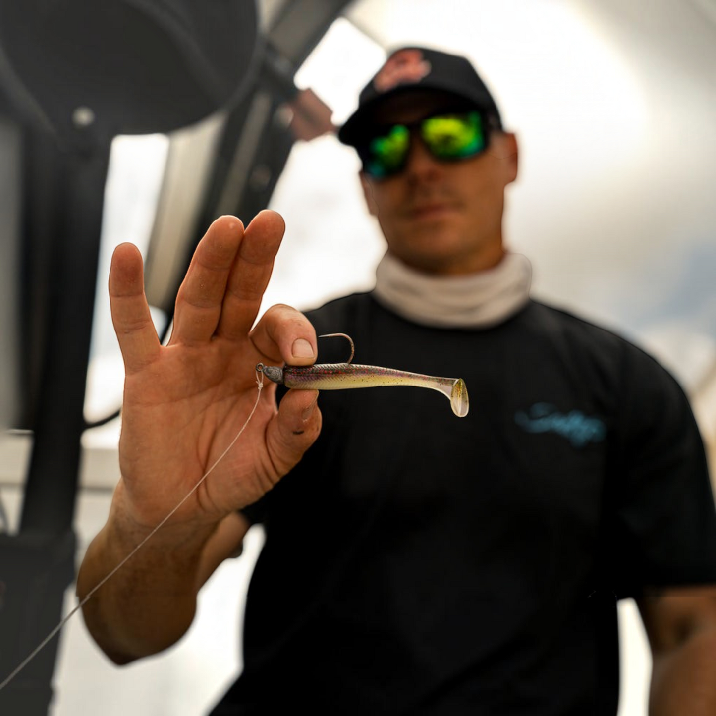 Dogfish Tackle & Marine angler holding a 3.4-inch 6th Sense Divine saltwater swimbait rigged on a jig head