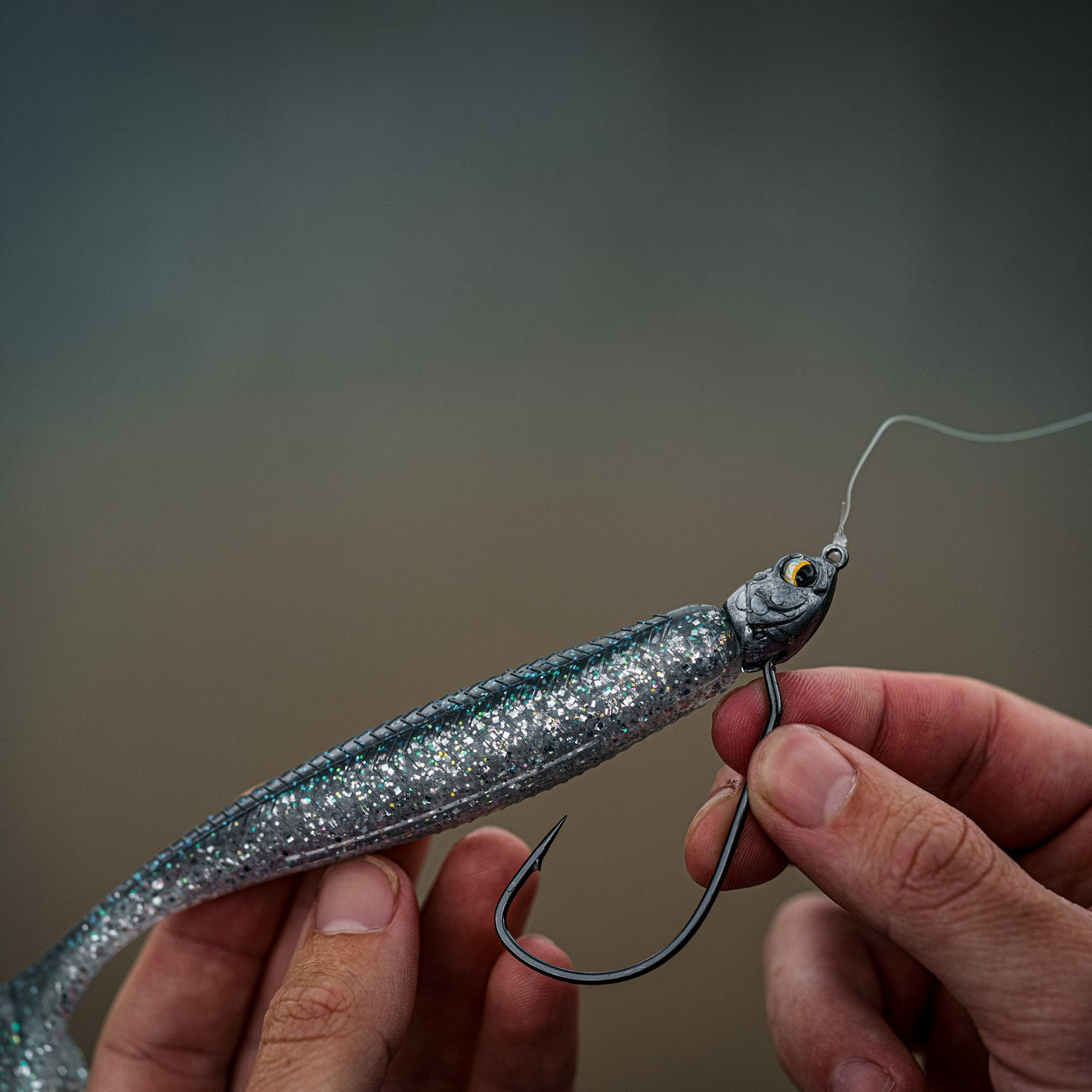 Dogfish Tackle & Marine 6th Sense Axle swimbait jig head with a silver glitter soft plastic lure held in hand