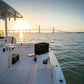 Dogfish Tackle & Marine black King Starboard chum cutter on a bucket on a boat at sunset with a bridge in the background.