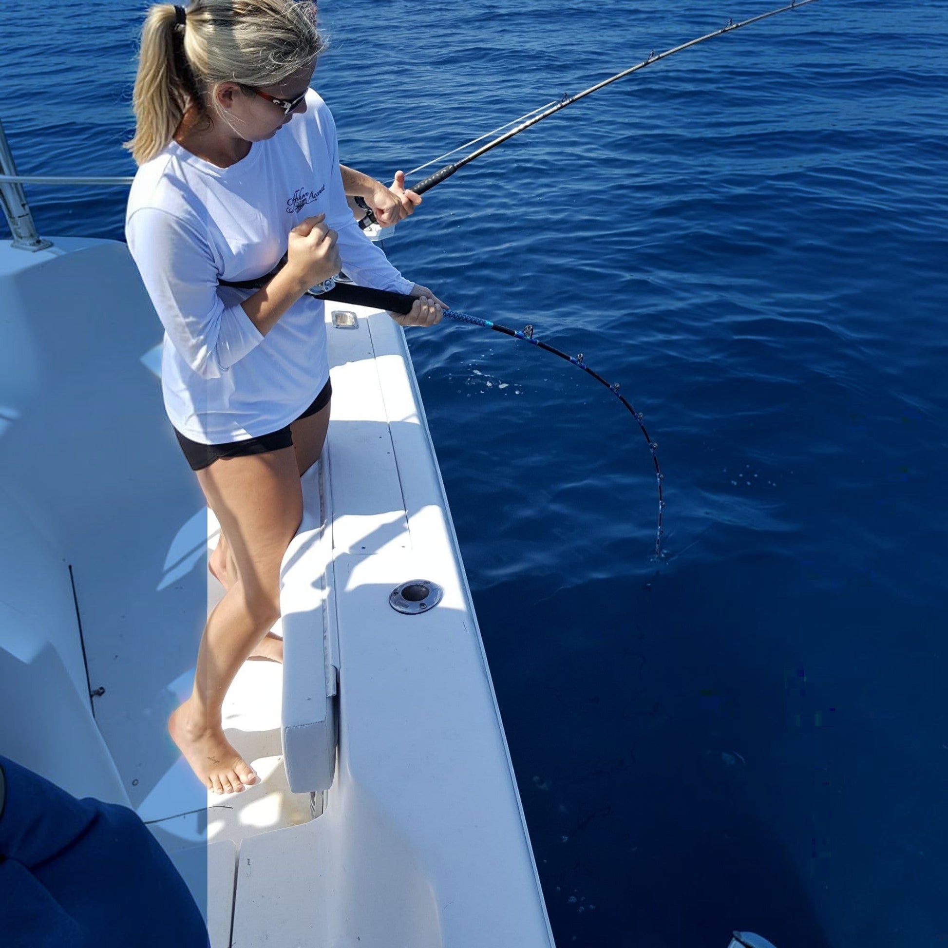 Woman fishing offshore on a boat with a Dogfish Stik 15H conventional rod, 7ft, 40-80lb line weight, EVA foam grip.