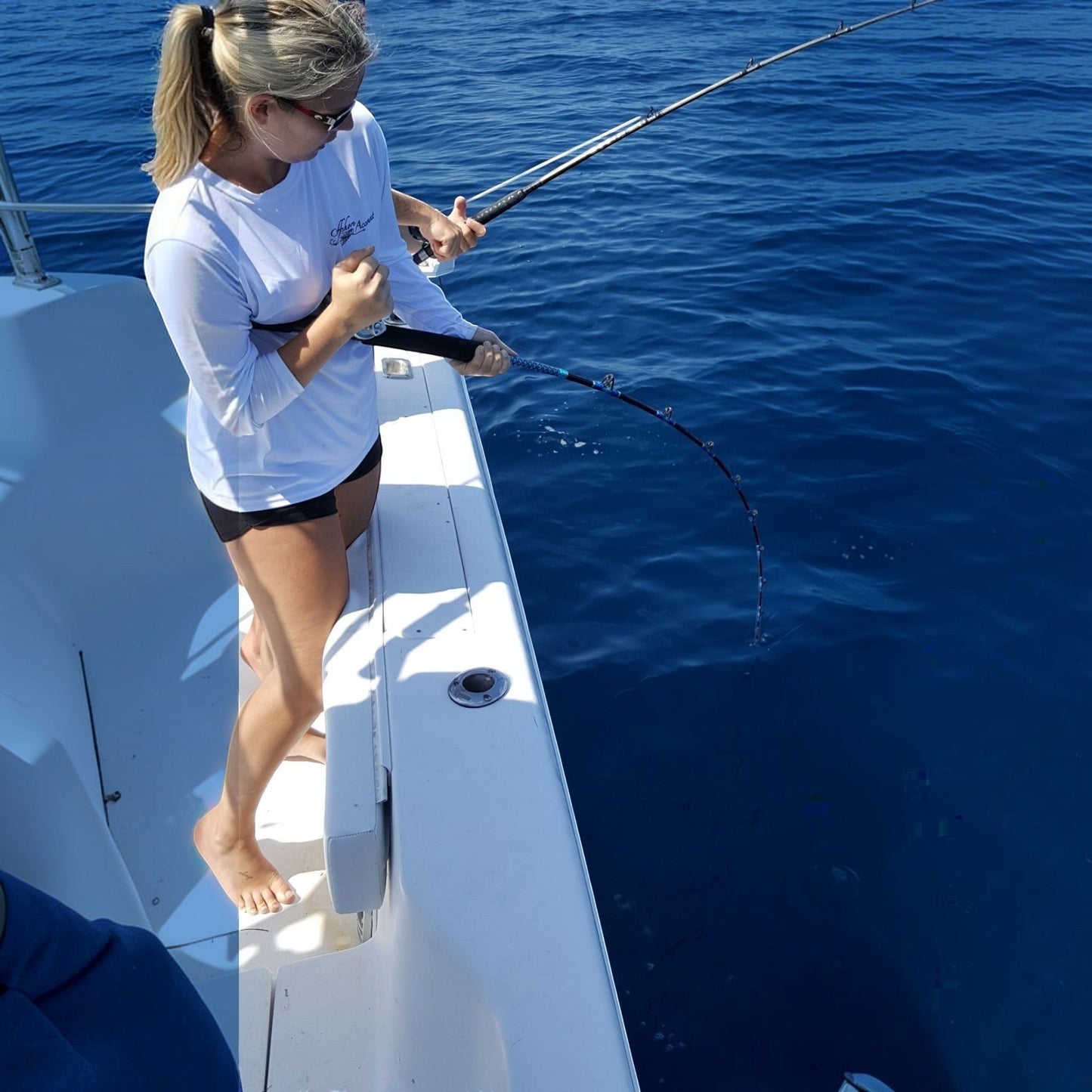 Woman fishing offshore on a boat with a Dogfish Stik 15H conventional rod, 7ft, 40-80lb line weight, EVA foam grip.
