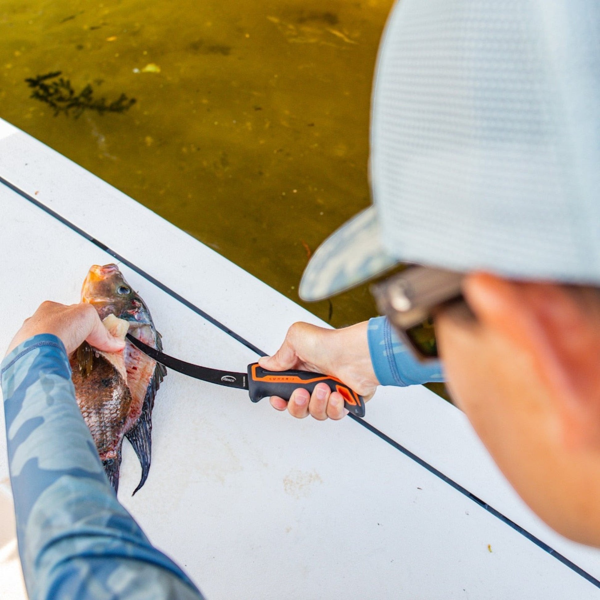 Dogfish Tackle & Marine Danco Lunar-I 7-inch micro flex fillet knife being used to clean a fish on a boat deck