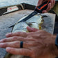 Dogfish Tackle & Marine Danco Lunar-I 7-inch fillet knife with black blade and orange grip filleting a fish on deck