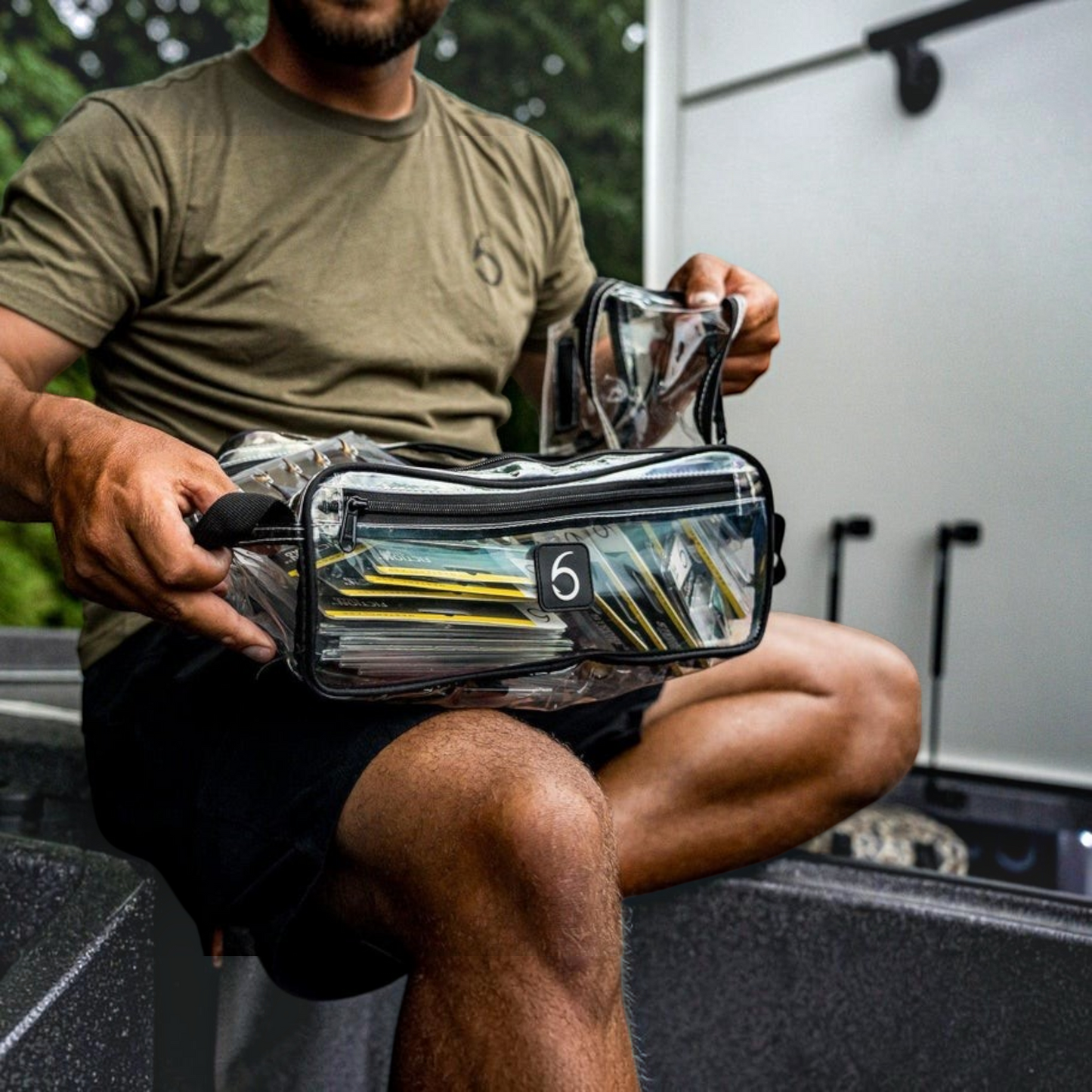 Dogfish Tackle & Marine 6th Sense large clear bait bag held by an angler for organizing soft plastic fishing lures