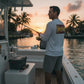 Dogfish Tackle & Marine white microfiber long sleeve shirt with Dont Tread On Me logo on back, fishing at sunset.