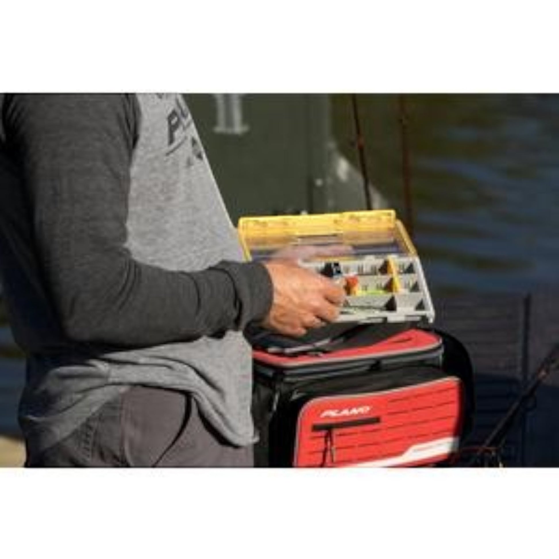 Dogfish Tackle & Marine angler holding a Plano Edge 3500 utility box with yellow lid and organized fishing tackle