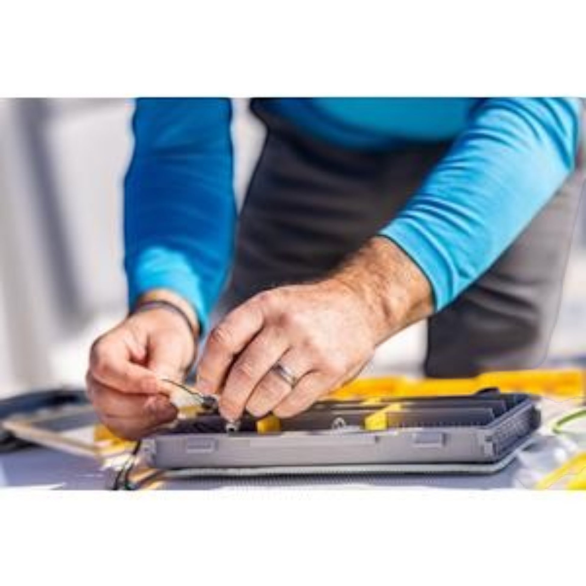 Dogfish Tackle & Marine angler organizing fishing gear in a grey and yellow Plano Edge 3500 utility tackle tray