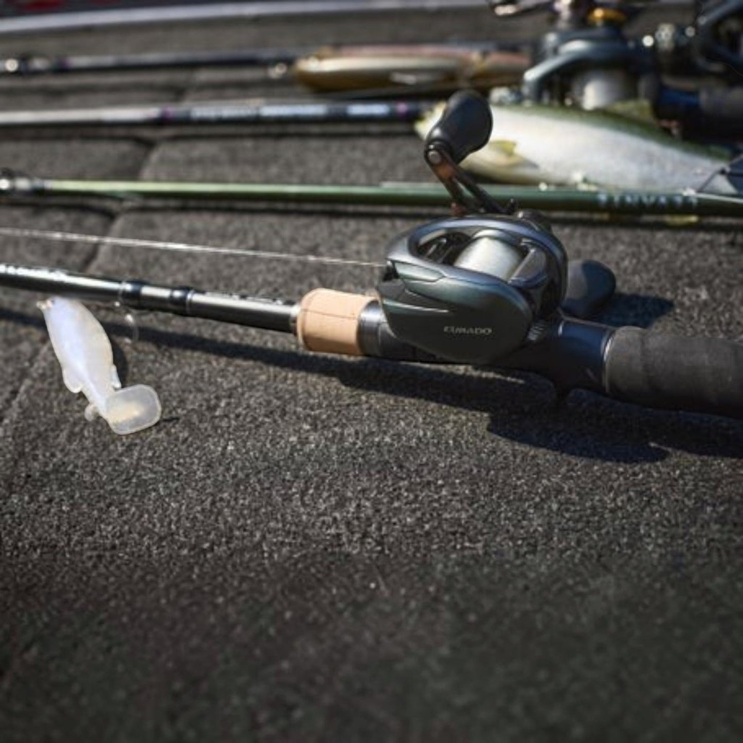 Dogfish Tackle & Marine Shimano Curado 150 M baitcasting reel in dark green with a tan cork handle grip and a soft plastic lure.