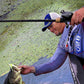 Dogfish Tackle & Marine angler with a bass, holding a Shimano Curado DC baitcasting reel and rod.