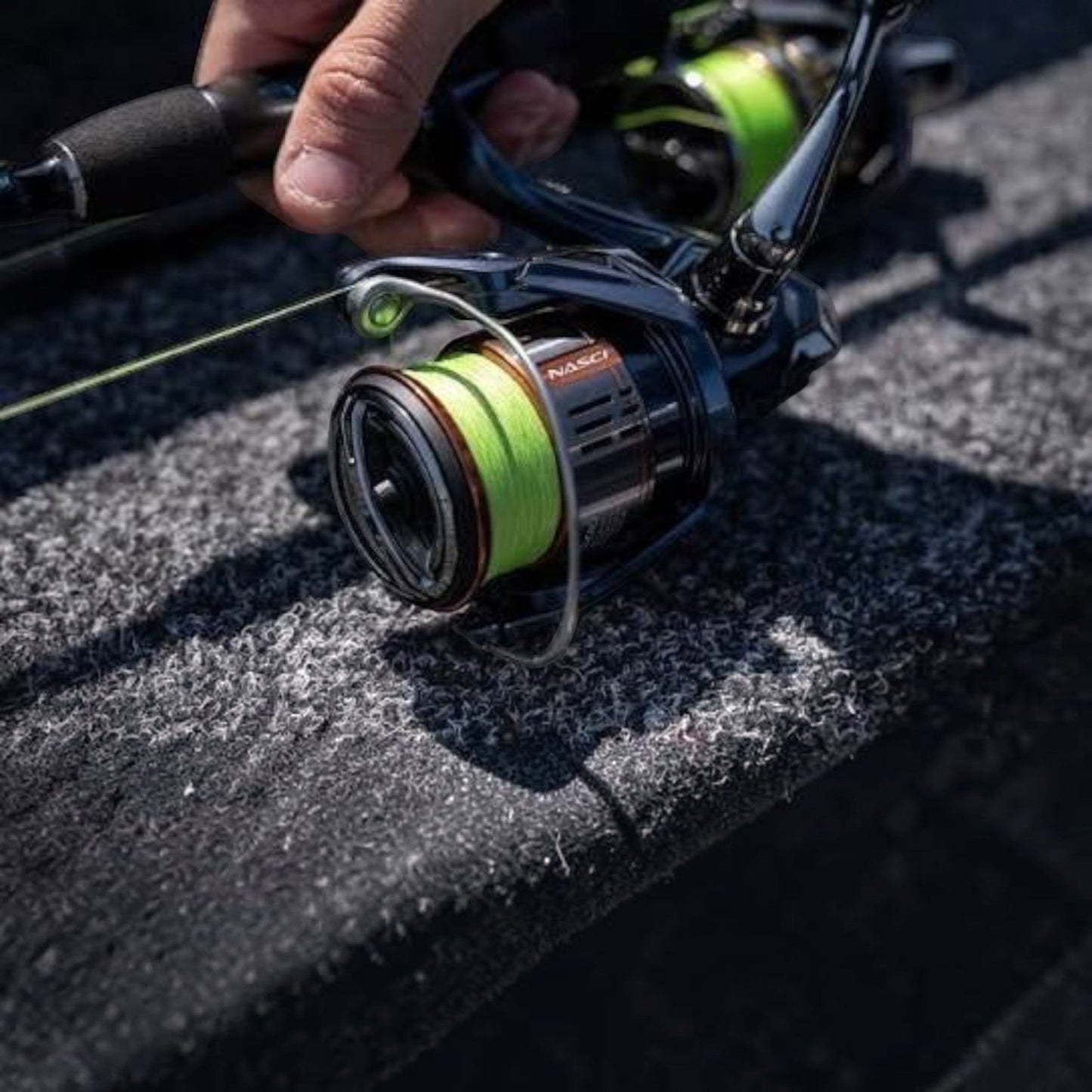 Dogfish Tackle & Marine Shimano Nasci FD spinning reel with neon green fishing line on a boat deck.