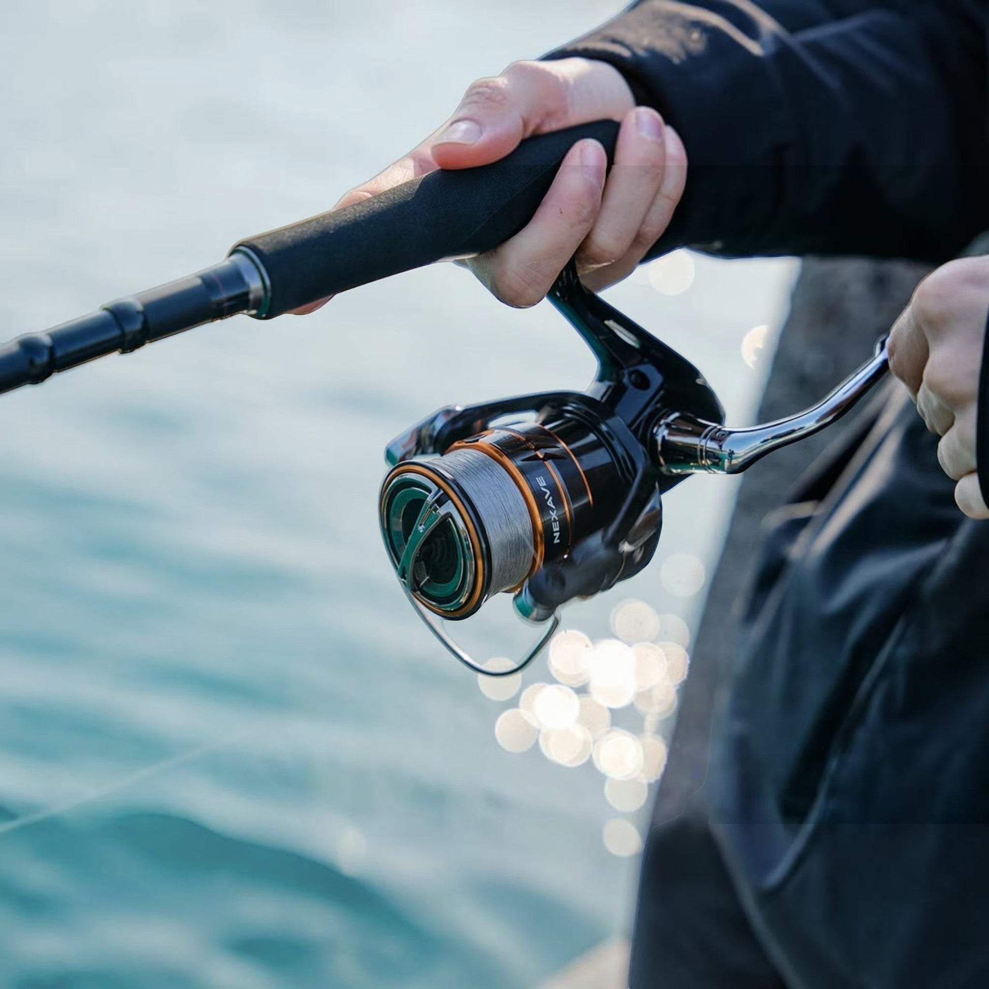 Dogfish Tackle & Marine Shimano Nexave FJ spinning reel with grey line, black and orange accents, held by a person fishing.