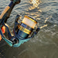 Dogfish Tackle & Marine Shimano Sahara FJ spinning reel, black and gold with white line, ready for fishing.