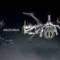 Shimano Sedona FJ spinning reel in silver and black with gold accents. Features HAGANE Gear and SilentDrive technology.