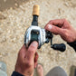 Dogfish Tackle & Marine Shimano Tranx B baitcasting reel, silver with black handle and green line. Close-up of hands holding the reel.