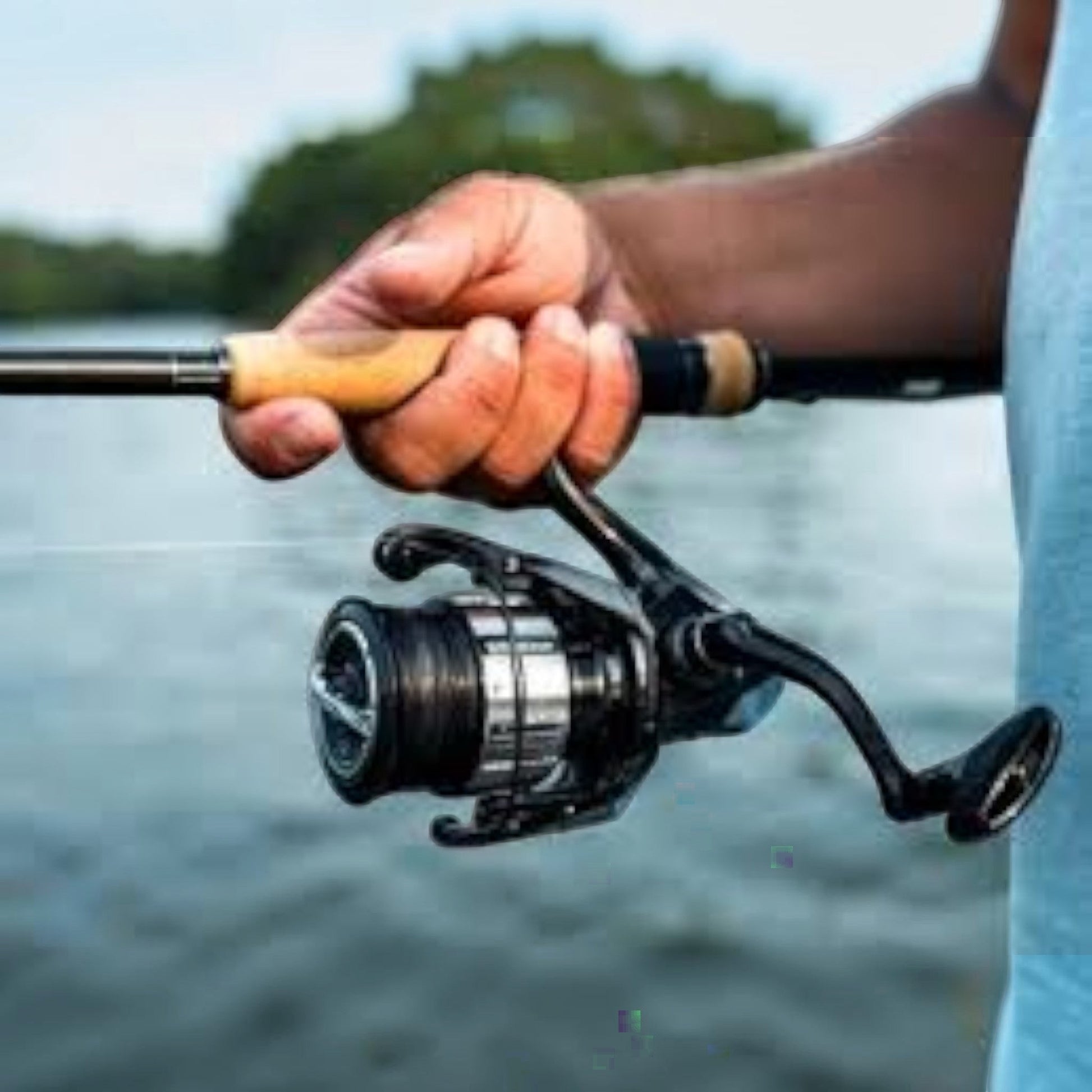 Dogfish Tackle & Marine Shimano Vanquish C spinning reel, black with silver accents, held by a person fishing.