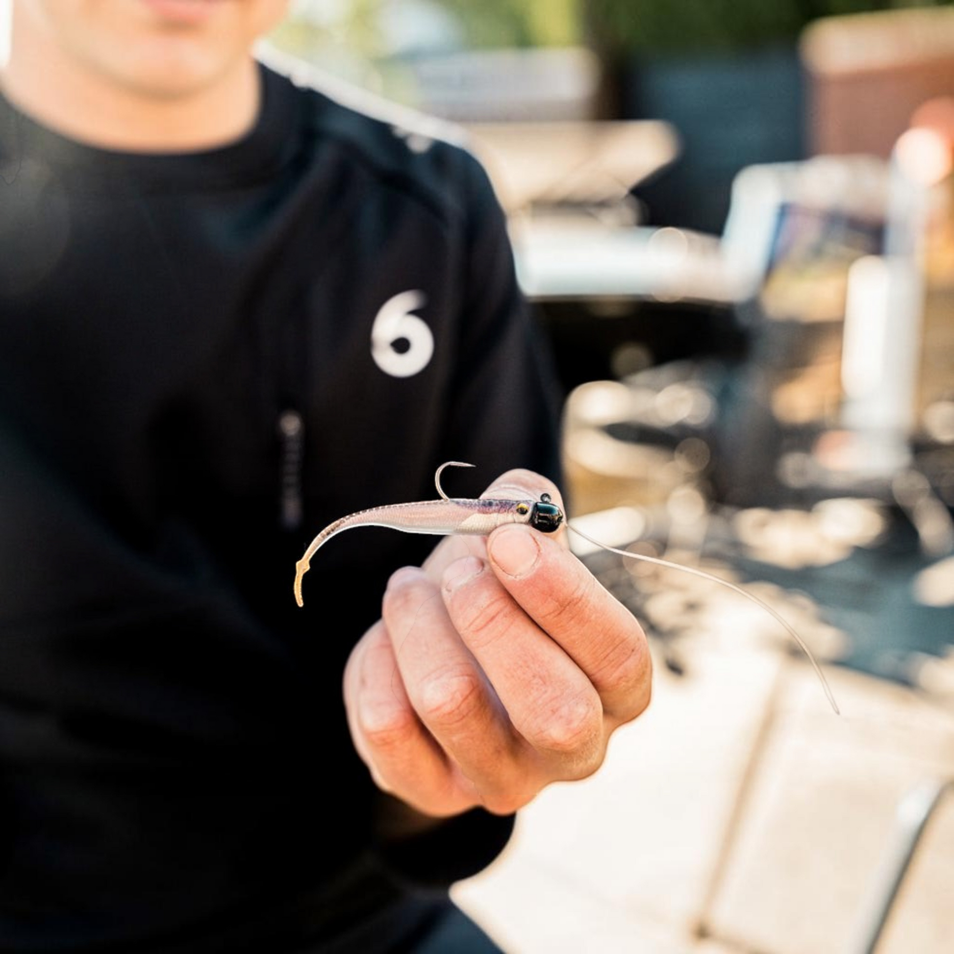 Dogfish Tackle & Marine 6th Sense Strobe Minnow soft plastic bait held by an angler for realistic fishing presentation