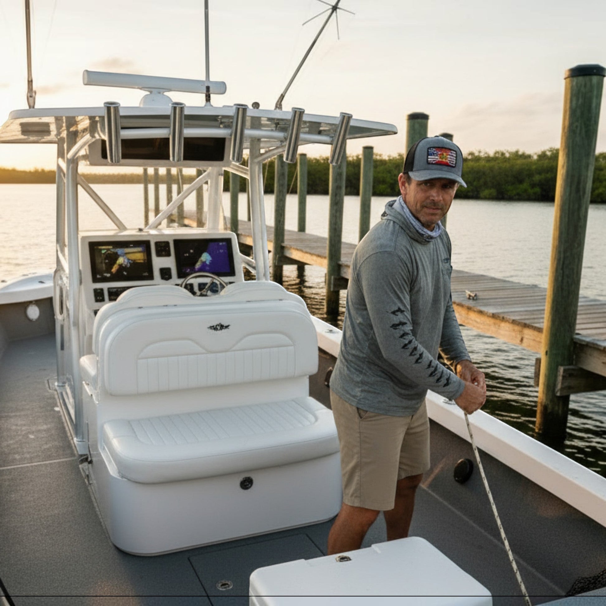 Dogfish Tackle & Marine man wearing a grey trucker hat with Florida flag patch and grey long-sleeve shirt.