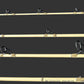 Three fishing rods with black line guides and metal reel seats laid out horizontally on a dark gray wood-grain surface.