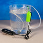Clear plastic container with water, green buoy, and USB battery backup device on a blue and gray background